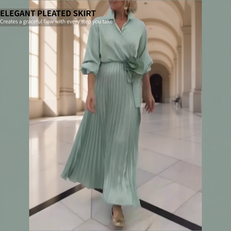 Elegant plisserad maxiklänning med blommig detalj i midjan