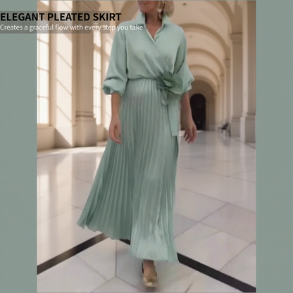 Elegant plisserad maxiklänning med blommig detalj i midjan