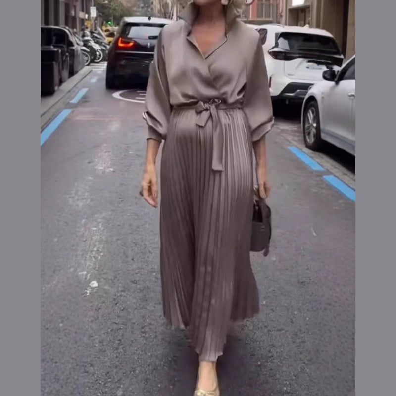 Elegant plisserad maxiklänning med blommig detalj i midjan