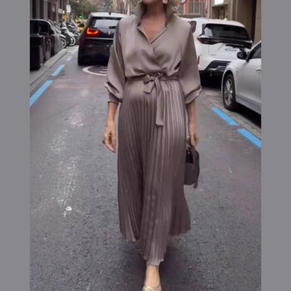 Elegant plisserad maxiklänning med blommig detalj i midjan